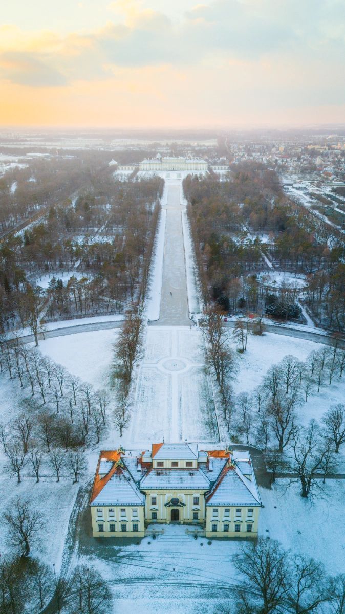 Luftaufnahme einer verschneiten Schlossallee im Abendlicht