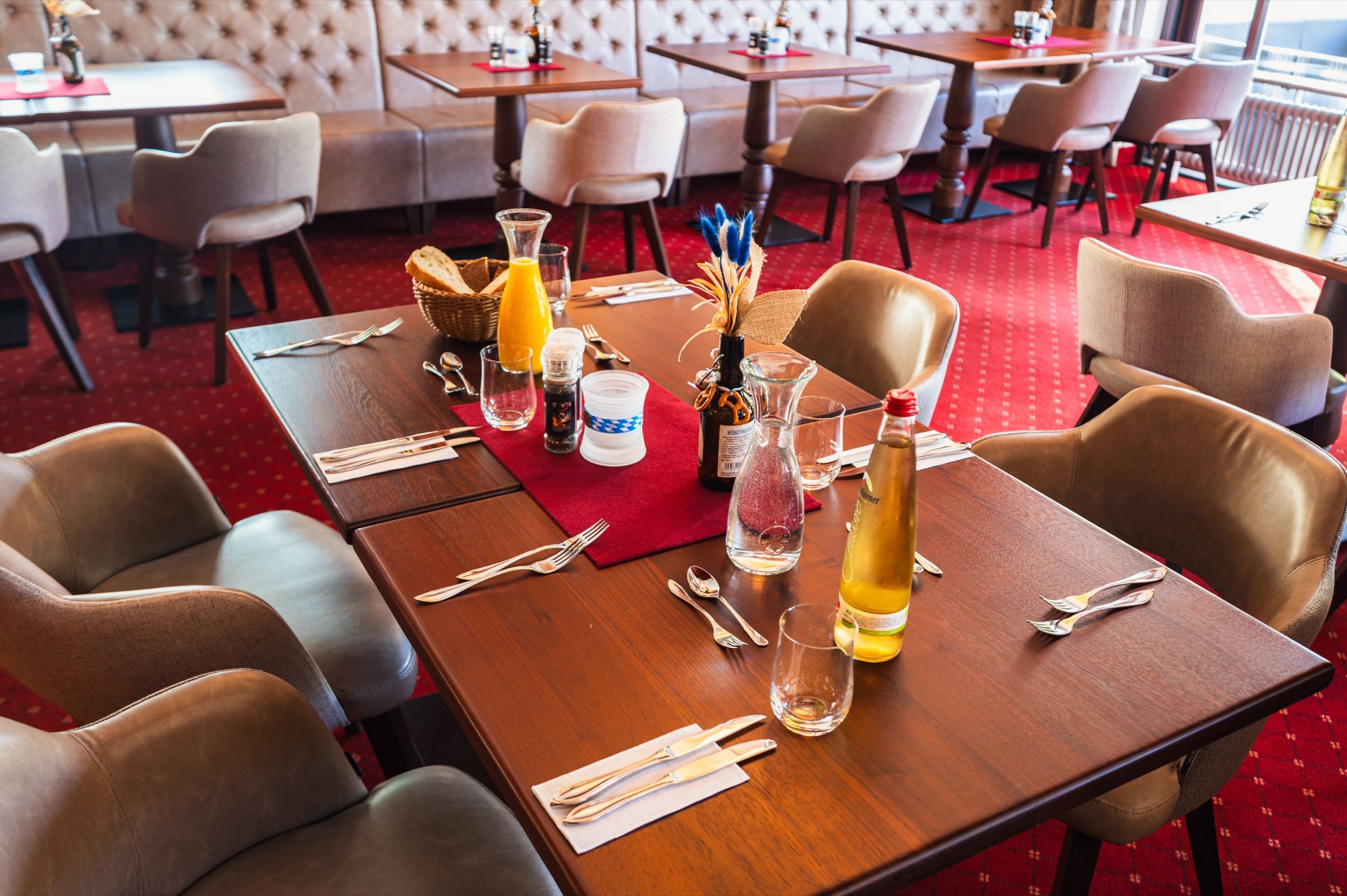 Gedeckter Frühstückstisch mit Saft und Brotkorb im Restaurant