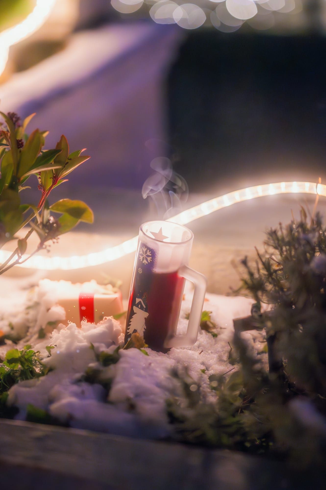 Glühweinbecher zwischen Schnee und Lichterkette