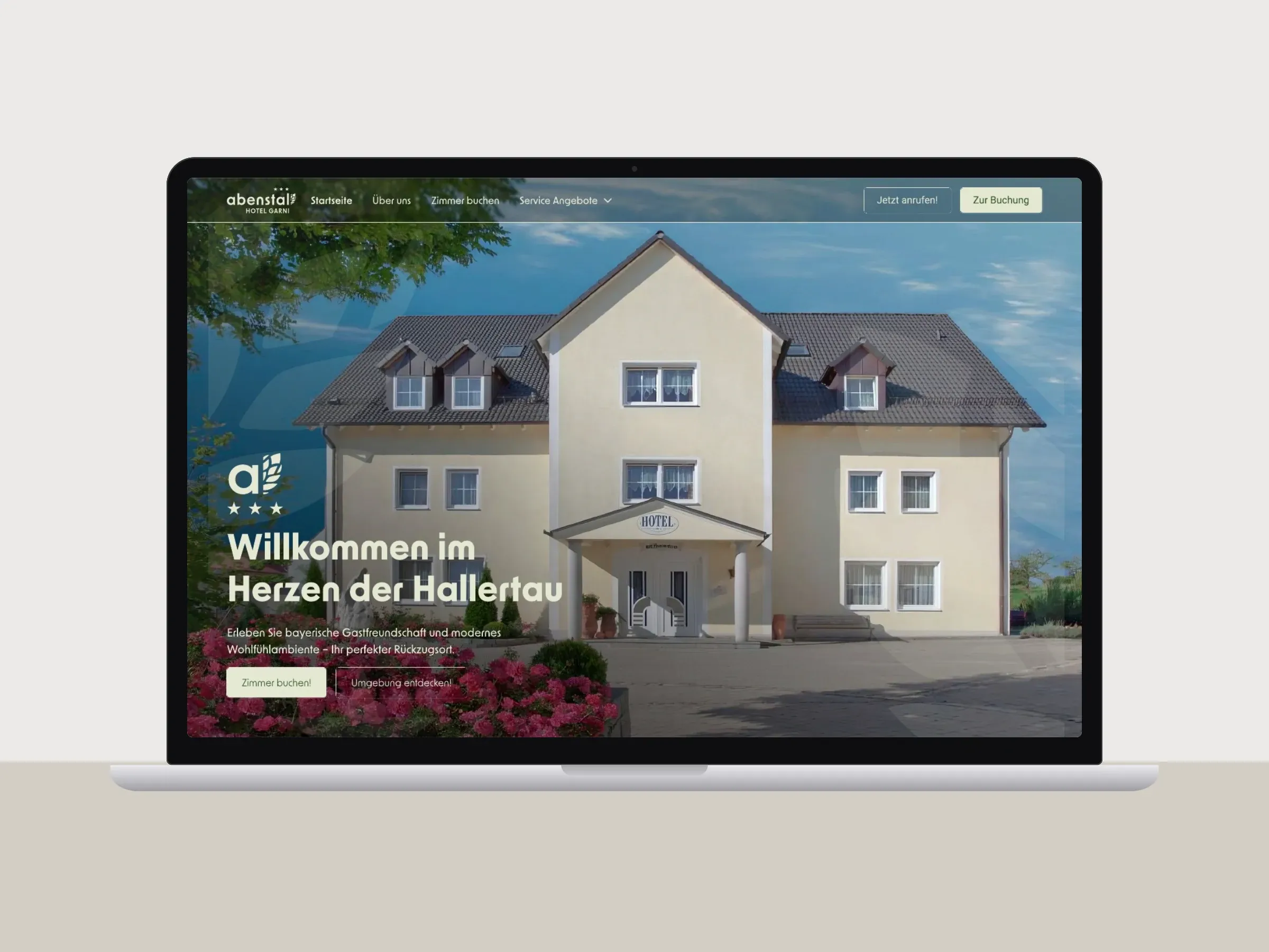 Webseite eines Hotel garni mit Hausansicht auf dem Laptop am Schreibtisch