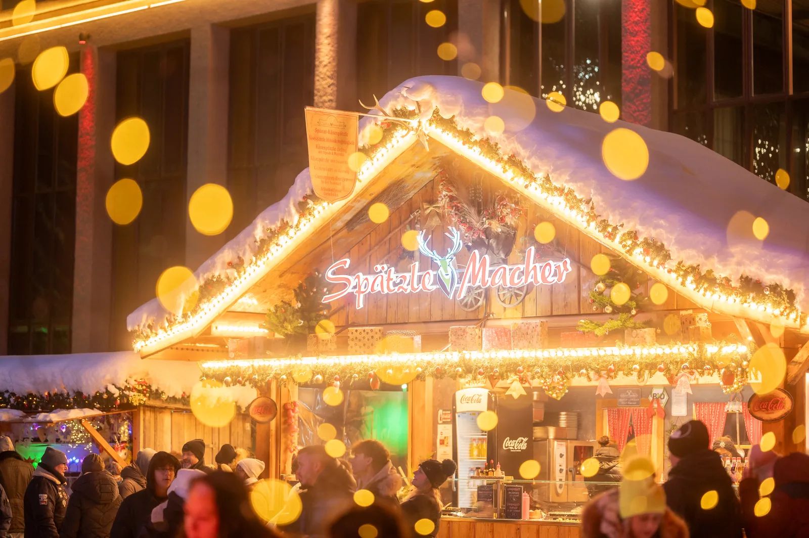 Beleuchtete Bude auf einem Weihnachtsmarkt am Abend